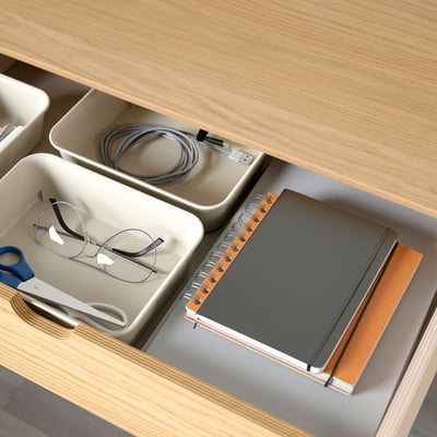 Caixón de escritorio organizado con xestión de cables e colectores de almacenamento para papelería.