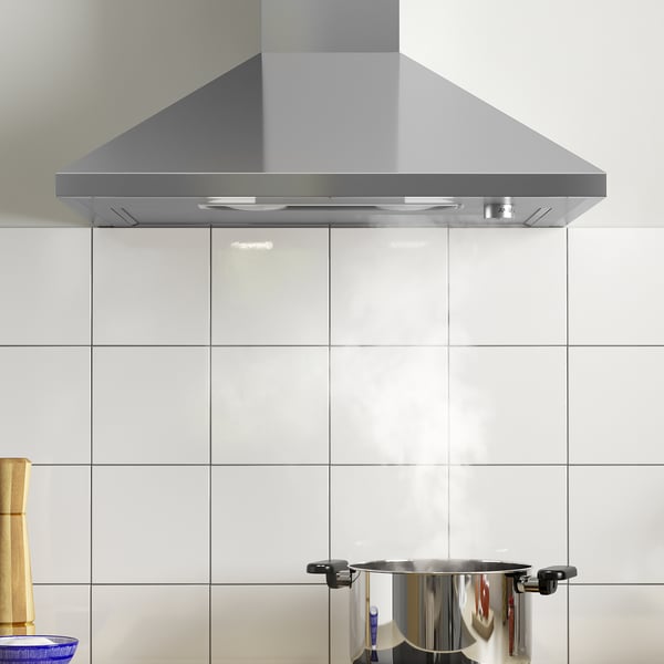 Capa de aceiro inoxidable con luz led montada sobre o backsplash da cociña de azulexos brancos.