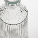 Caraffa de vidro clara e texturizada con cristas verticais e parte superior detallada, reflectindo elegancia e calidade.