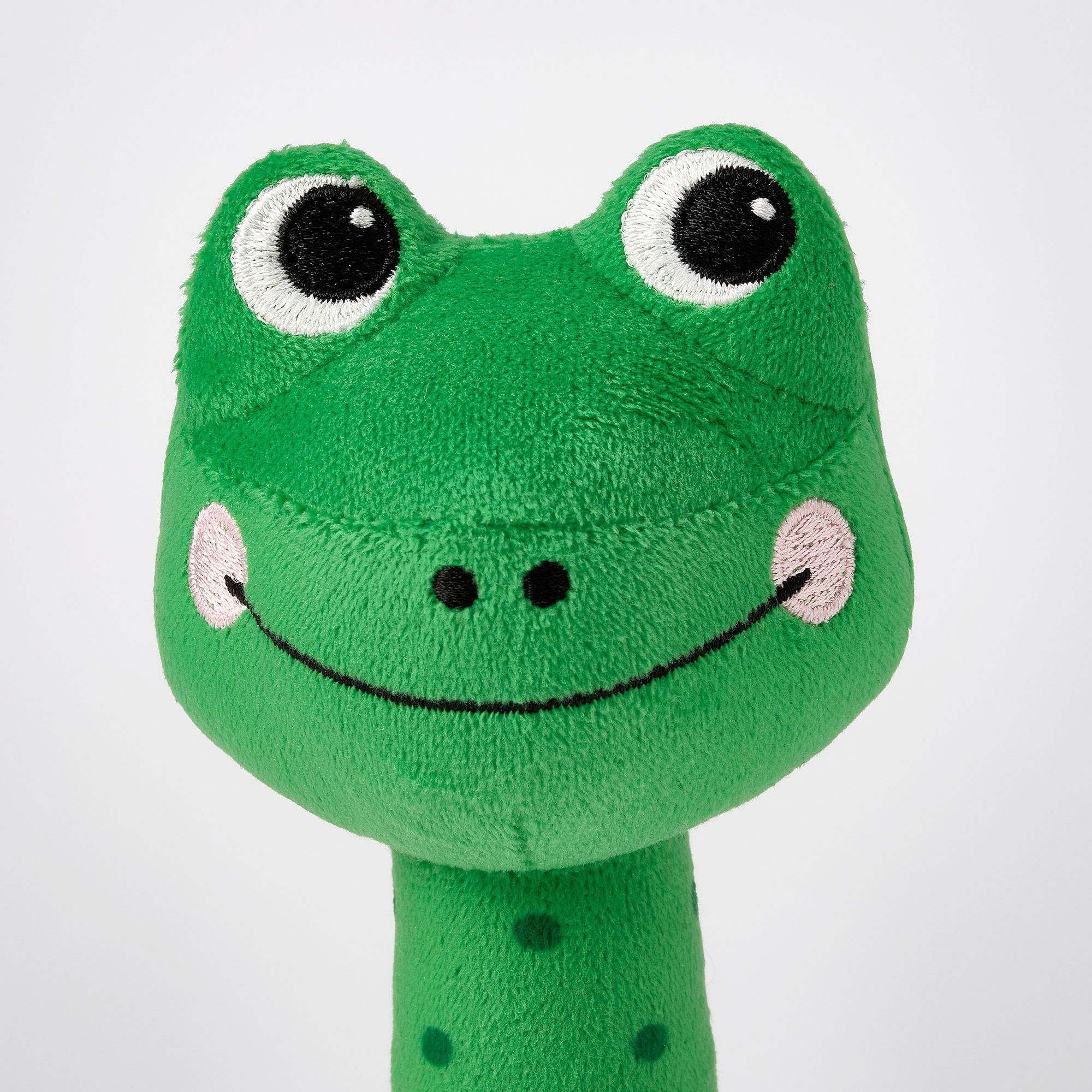 Xoguete de ra de peluche verde brillante con detalles vivos; ollos grandes e redondos e amplo sorriso, que exsuda calidade e textura suave.