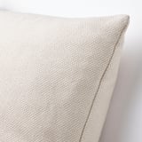 Primeiro plano de tecido acolchado beige que amosa textura de tecido e recheo gordo.