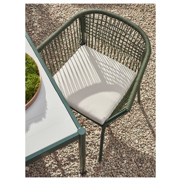 Cadeira exterior verde moderna con coxín de raias brancas; Deseñado para balcóns ou patios.