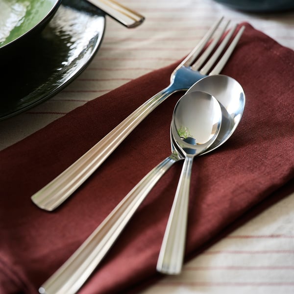 SJUGÄLSHAJ cutlery on burgundy napkin. Aceiro inoxidable, deseño elegante.
