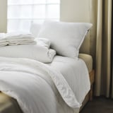Cama grande, ben feita con piveta branca SKOGSFRÄKEN e almofadas, suave e fluffy, iluminación brillante.