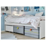 Cama branca para nenos IKEA SLÄKT con almacenamento e caixas de tecido.