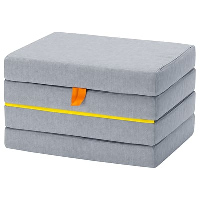 Un colchón para nenos gris, rectangular e plegable en gris claro con acentos amarelos e laranxas, deseñado para xogar e durmir.