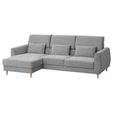 Moderno sofá gris en forma de L con respaldo alto, pernas de madeira e dous coxíns.