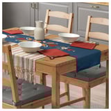 Conxunto de comedor de madeira rústica con corredor de mesa azul, cuncas brancas, servilletas vermellas e coxíns tufted.