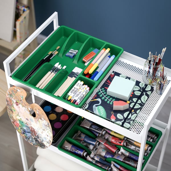 Carro de arte con bandexas verdes que contén pinceis, marcadores, pinturas e caderno.