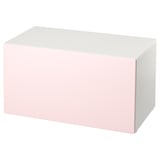Un banco de almacenamento de smastad en rosa claro e branco. Forma rectangular, deseño sinxelo, ideal para o almacenamento de xoguetes.