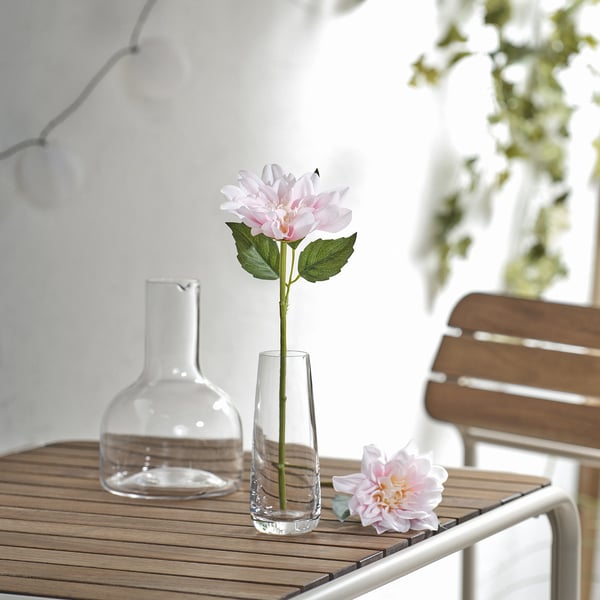 SMYCKA dalia rosa clara en vaso de vidro. Flor pequena e realista sobre a mesa.