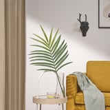 Gran folla artificial verde SMYCKA en vaso sobre a mesa, cadeira de mostaza, tiraxe gris, cabeza de cervo.