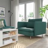 Sala de estar con cadeira de brazos SÖDERHAMN verde azul, sofá, plantas, estantes, alfombra e grandes fiestras.