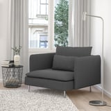 Sala de estar minimalista moderna con gran cadeira de brazos gris SÖDERHAMN, mesa lateral metálica, libros, vaso, lámpada e gran xanela.