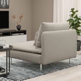 Sala de estar moderna con sofá seccional SÖDERHAMN gris claro, mesa lateral negra con cunca de café e libros.