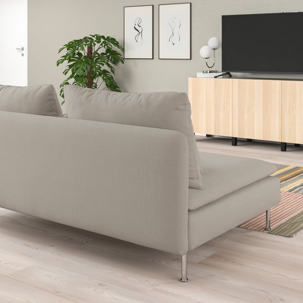 Sala de estar minimalista con sofá SÖDERHAMN, soporte de televisión, alfombra colorida, plantas e arte de parede.