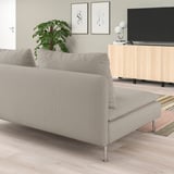 Sala de estar minimalista con sofá SÖDERHAMN, soporte de televisión, alfombra colorida, plantas e arte de parede.