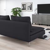 Sala de estar moderna con gran sofá SÖDERHAMN negro, alfombra gris, planta, televisión, estampas de arte. Espazo e minimalista.