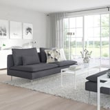 Sala de estar moderna con sofá gris SÖDERHAMN, mesa de café branca e grandes fiestras.