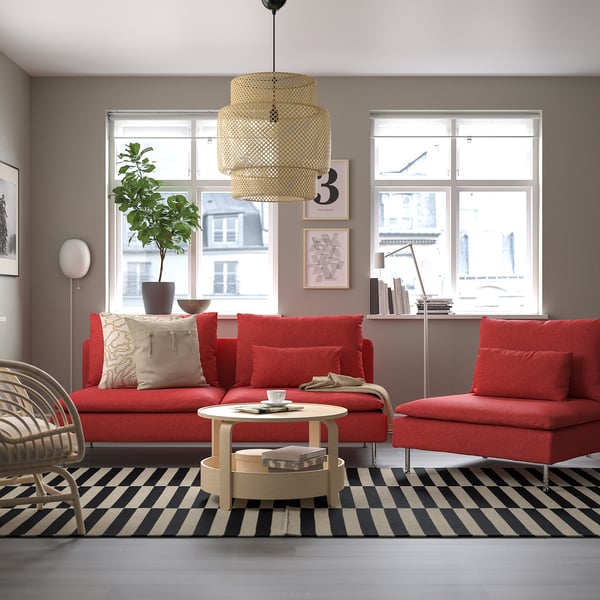 Sala de estar moderna con sofá vermello, alfombra, mesa de café, fiestras de vista á cidade e luz colgante.