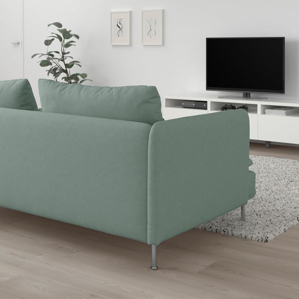 Sala de estar moderna con sofá verde claro SÖDERHAMN, consola de televisión branca e planta. Deseño limpo e minimalista.