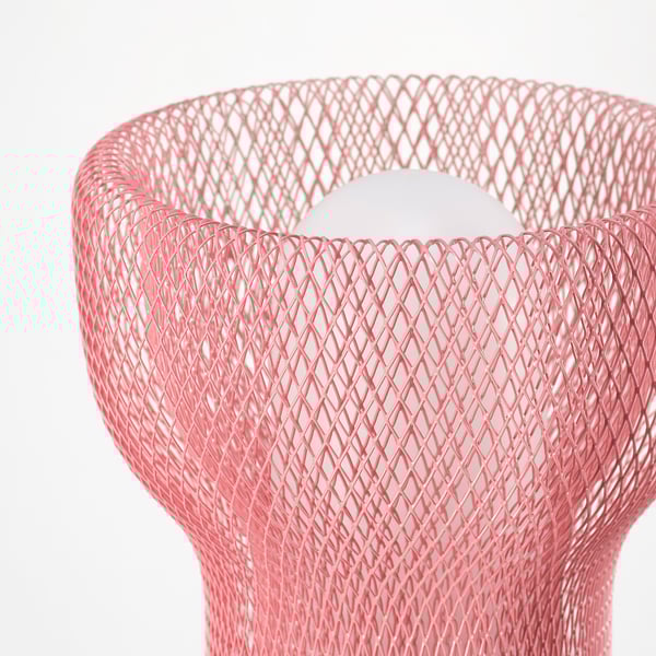 Primeiro plano dunha moderna lámpada de malla rosa. Deseño elegante, patróns intrincados, emitindo luz suave.
