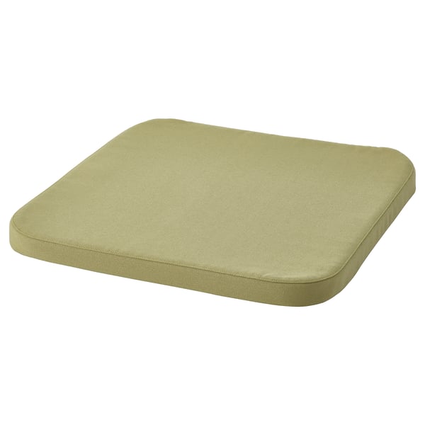 Un coxín STAGGSTARR verde claro cunha forma suave e rectangular. É un deseño cómodo e acolchado para adicional soporte de asento.