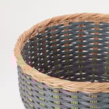 Cesta de vimbio con deseño tecido; tons marróns claros e gris escuros; patróns complexos e construción robusta.