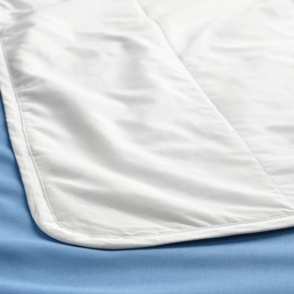 Duvet branco crocante, liso e ben dobrado sobre roupa de cama azul claro.