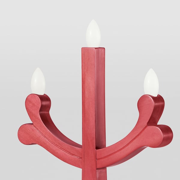 Candelabro vermello con tres lámpadas led acendidas, creando un brillo cálido. Feito de piñeiro cun acabado suave, ofrece un ambiente acolledor.