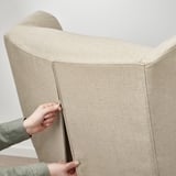 Tira a man cremalleira na cuberta da cadeira beige clara. Fácil acceso para a limpeza.