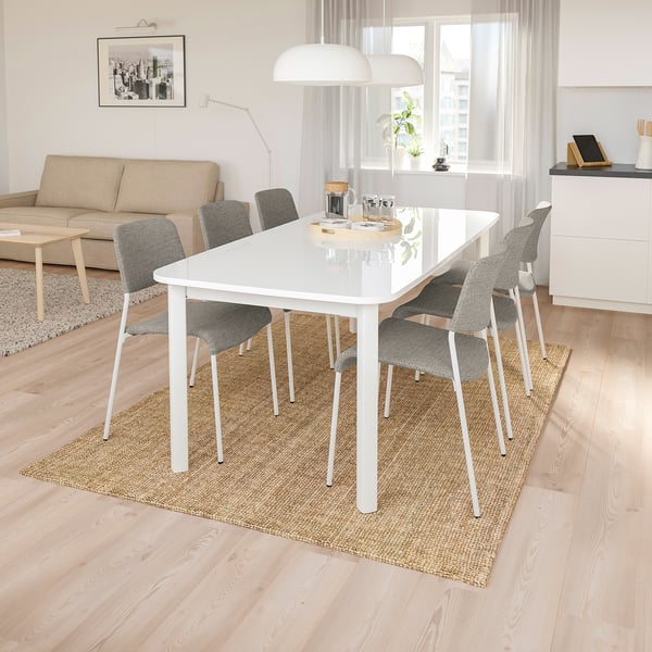 Conxunto de comedor STRANDTORP de 6 asentos con mesa extensible e cadeiras grises sobre alfombra beige.