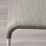 Primeiro plano da cadeira de tecido gris moderno, mostrando textura de calidade e efecto de coxín.