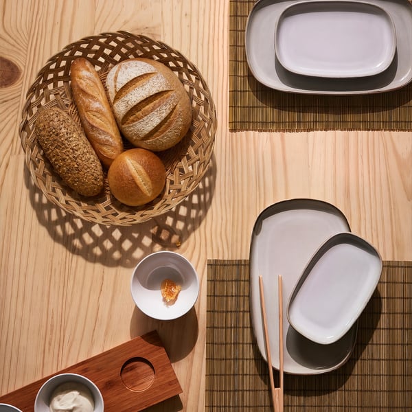 Cesta de pan de ratán con pan sobre mesa de madeira.