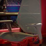 Cadeira de xogador vermella e gris con respaldo de malla, soporte de auriculares e tiras de luz rgb.