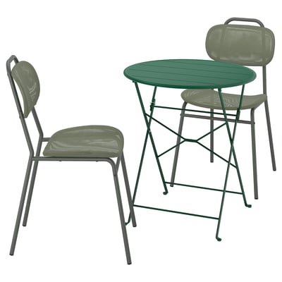 Un conxunto de comedor ao aire libre verde SUNDSÖ cunha mesa redonda plegable e dúas cadeiras apilables en gris con asentos e respaldos verdes.