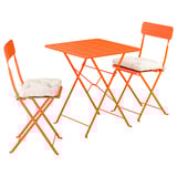 Conxunto de patio de metal laranxa brillante con mesa cadrada e dúas cadeiras plegables, cada unha con coxíns crema para uso exterior.