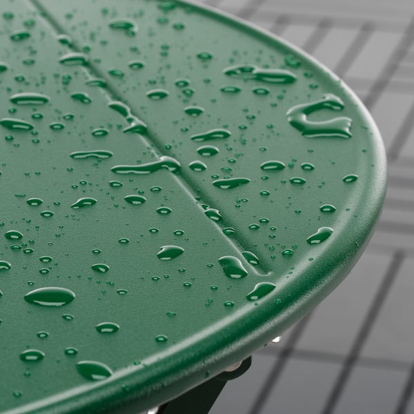 Mesa exterior de plástico verde con gotas de auga, pregamentos para almacenamento.
