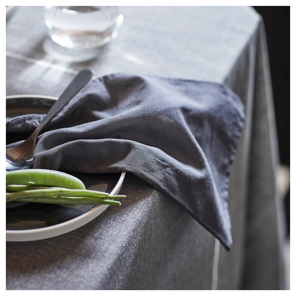 Mesa con servilletas SVARTSENAP grises, prato sinxelo e verduras verdes. Elegante comedor gris.