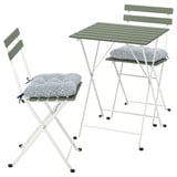 Un conxunto de mobles para exteriores verde e branco TÄRNÖ. Inclúe unha mesa plegable e dúas cadeiras con coxíns. O conxunto é compacto e elegante.