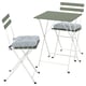 Un conxunto de mobles para exteriores verde e branco TÄRNÖ. Inclúe unha mesa plegable e dúas cadeiras con coxíns. O conxunto é compacto e elegante.