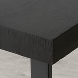 Mesa de comedor extensible negra con elegantes patas metálicas, mostrando revestimento de alta calidade e deseño robusto.