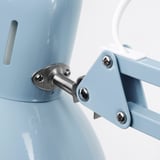 Primeiro plano dunha xunta axustable de lámpadas metálicas azul claro, que mostra parafusos e bisagra metálica para estabilidade.
