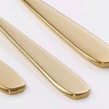 Fervenza de cubertas de ouro brillantes, pulidas, elegantes e sofisticadas, dispostas artesanalmente sobre un fondo branco puro.