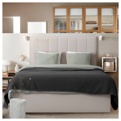 Dormitorio moderno acolledor con cabeceira TJÅLLE en beige, tecido de acrobacias, forma rectángulo, deseño acolchado suave, roupa de cama correspondente, armarios de madeira, paredes.