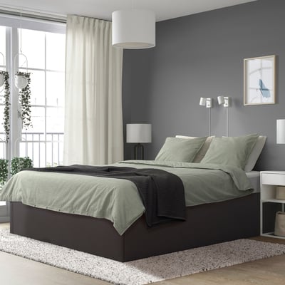 Cama moderna TJÅLLE en gris escuro con almacenamento, roupa de cama gris, cortinas, xanela grande e luces de parede.