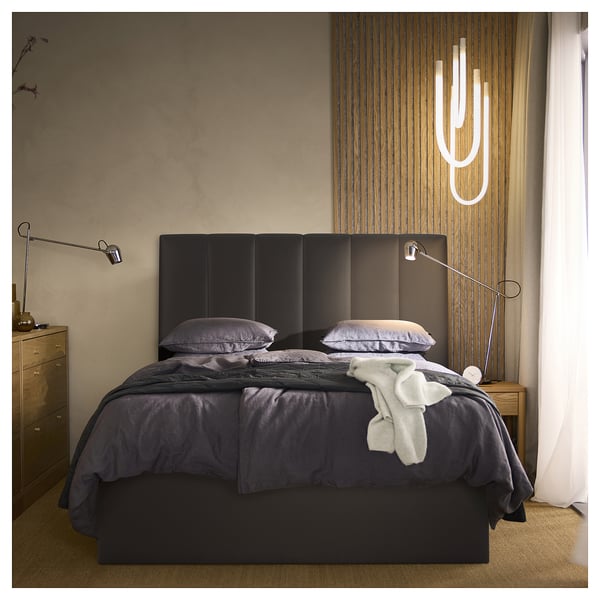 Dormitorio moderno con cama TJÅLLE, acolchado, iluminación e caixóns.