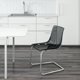 Cociña moderna con armarios elegantes e lavabo. En primeiro plano, cadeira TOBIAS transparente con asento e respaldo flexibles, deseñada para mesturarse coa contorna.