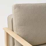 Primeiro plano do recuncho de mobles tapizados beige. Tecido suave e invitante con robusto repousabrazos de madeira.
