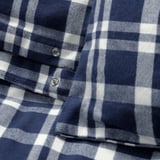 Primeiro plano de tecido de flanela de cadros azul e branco, mostrando a súa textura suave e patrón nítido.